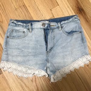 Free People denim shorts with lace trim.